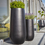 Blumentopf hoch in Schwarz, ideal für moderne Außenbereiche wie Terrassen, Balkone und Gärten. Diese stilvollen Blumenkübel mit hoher, geschwungener Form bieten eine exklusive Optik und eignen sich perfekt für große Pflanzen oder dekorative Arrangements. Das wetterfeste Material sorgt für Langlebigkeit und Widerstandsfähigkeit gegen Witterungseinflüsse. Durch ihr minimalistisches Design passen sie harmonisch in verschiedene Umgebungen und setzen stilvolle Akzente.